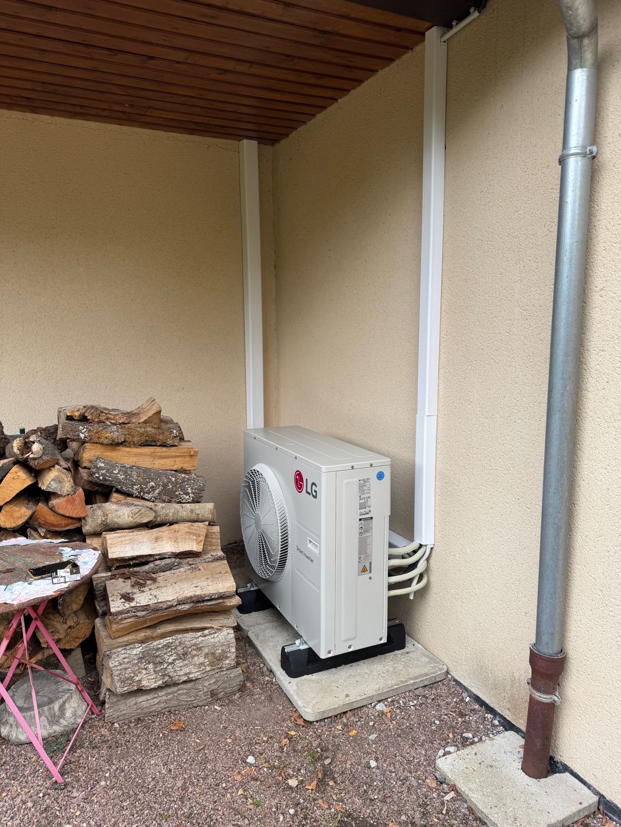 Unité extérieure de climatisation réversible LG installée par AUDRIEU sous un auvent, Honfleur