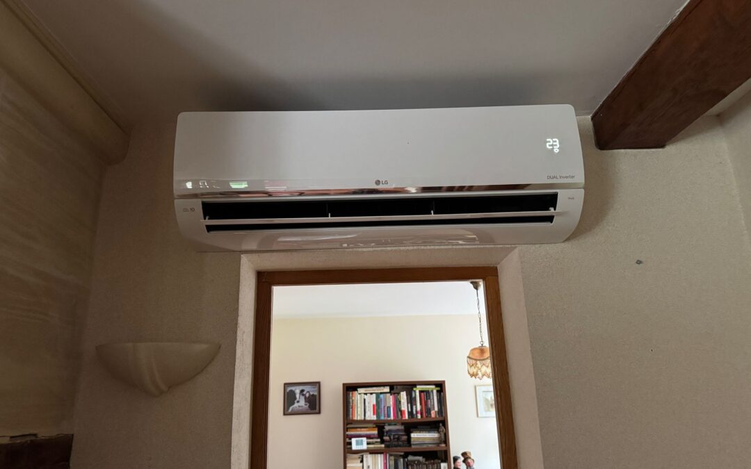 Unité intérieure de climatisation réversible LG Dual Inverter installée par AUDRIEU au-dessus d'une porte, Honfleur