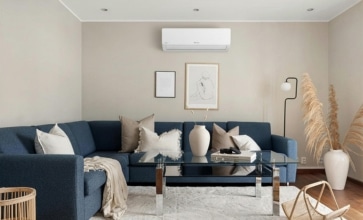 Salon cosy avec canapé bleu équipé d’une climatisation réversible, idéal pour une résidence secondaire