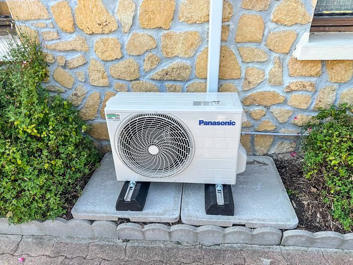Unité extérieure de climatisation Panasonic posée sur socle